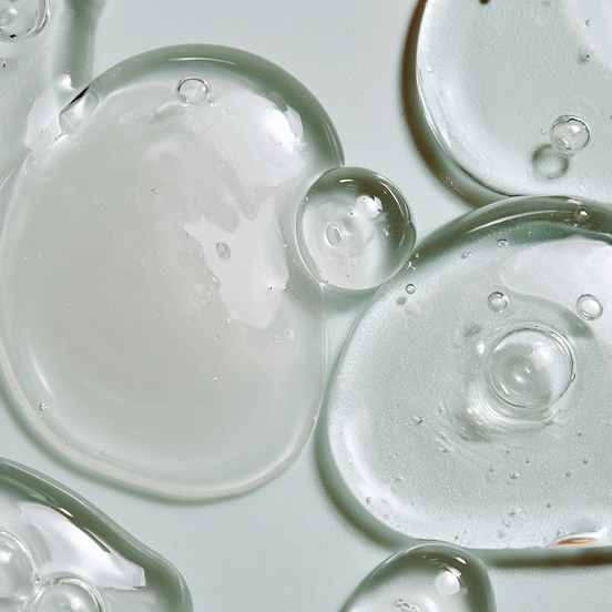 Close-up of transparent niacinamide serum bubbles on a light background