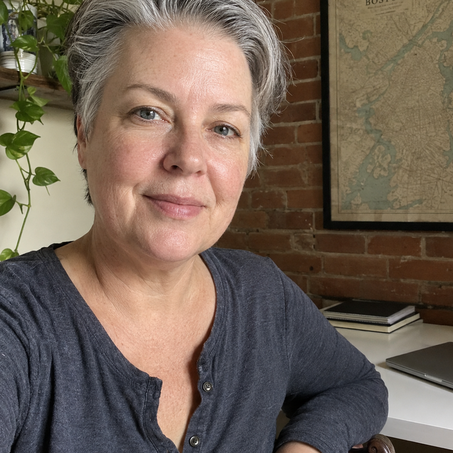 Woman with short gray hair wearing a dark gray shirt