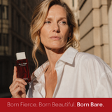 Woman in a white shirt holding Biomella Born Bare Eau de Parfum bottle